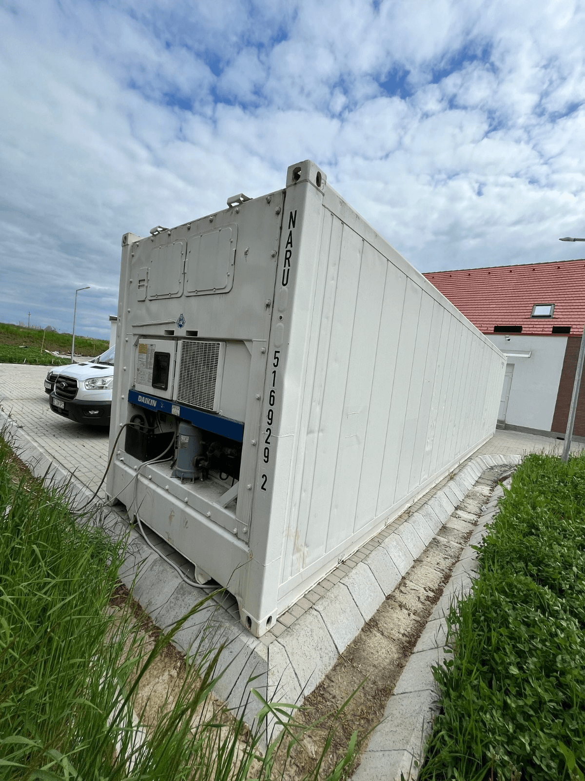 Container frigorific așezat pe fundație, cu agregatul vizibil